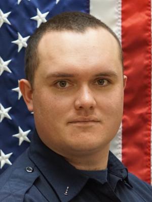 Photo of Kyler Monares in front of a flag