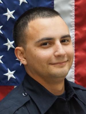 Photo of David Vaszquez in front of a flag