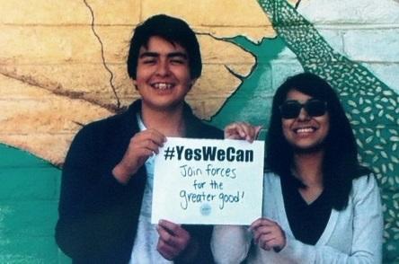 Jeffery and Yesenia holding a sign
