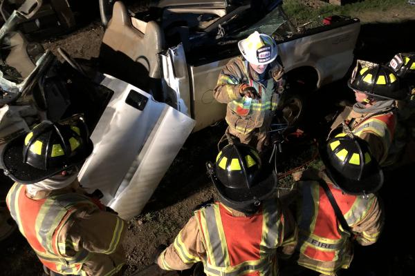 Photo of FireFighters with mangled car